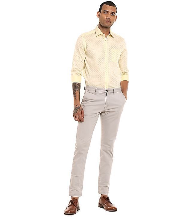 Dressing in a light yellow shirt, gray pants, a young attractive black guy  is standing by a triangle structure, looking at you Stock Photo - Alamy